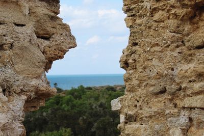 Rock formations by sea against sky