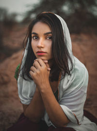 Portrait of beautiful young woman sitting outdoors