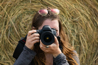 Portrait of woman photographing outdoors
