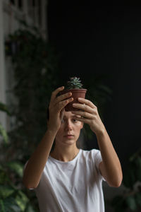 Close-up of woman gardener holding houseplant in her hands. love plants, hobby, home gardening.