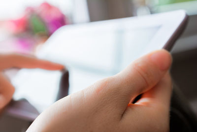 Close-up of hand touching digital tablet