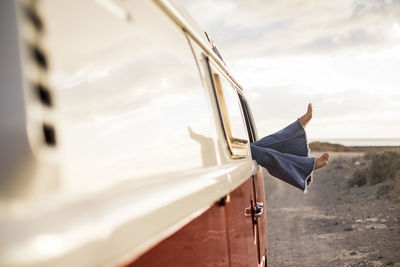 Low angle view of woman with umbrella against sky