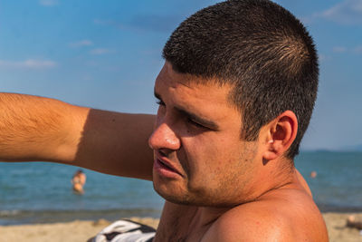 Close-up portrait of young man on beach