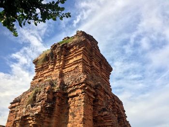 Low angle view of old ruin building against cloudy sky