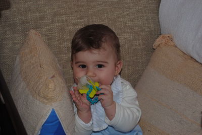 Portrait of cute boy holding toy at home