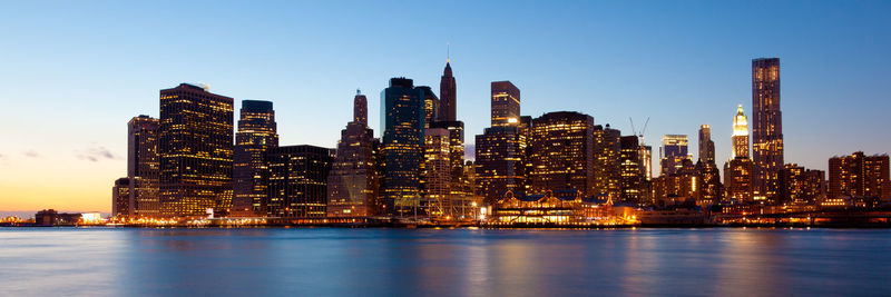 Illuminated buildings in city against sky