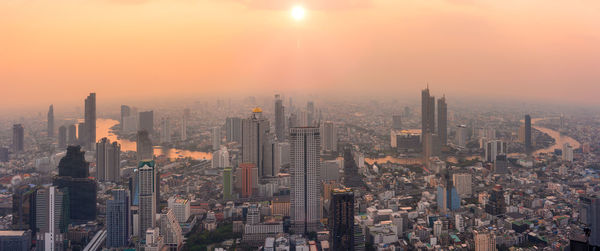 Aerial view of cityscape against sky during sunset