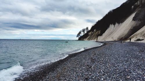 Scenic view of baltic sea by mountain against cloudy sky