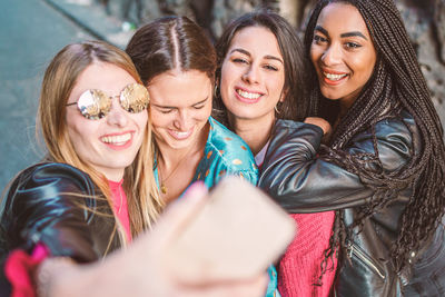 Portrait of a smiling young woman taking selfie with their smartphone 