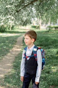 Happy boy with a backpack and a cap goes to school. the beginning of the new school year 