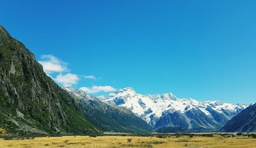 Scenic view of snowcapped mountains against blue sky