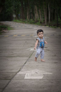 Full length of cute boy walking on footpath