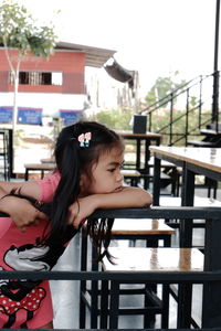 Girl and woman standing on table against railing