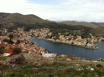 Aerial view of townscape by mountain against sky