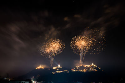 Low angle view of firework display at night