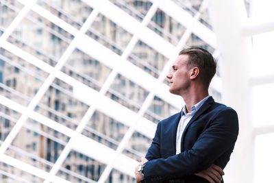 Thoughtful young businessman standing outdoors