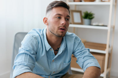 Portrait of serious man using laptop at home