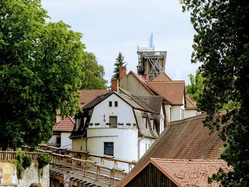 Houses amidst trees and buildings against sky