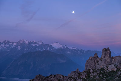 Scenic view of snowcapped mountains against sky at night