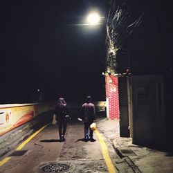 Blurred motion of people walking on road at night