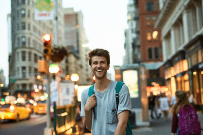 Portrait of young man standing on street in city