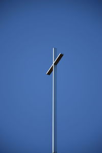 Low angle view of windmill against clear blue sky