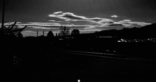 Silhouette of railroad tracks in city at dusk