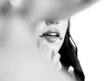 Close-up portrait of young woman against white background