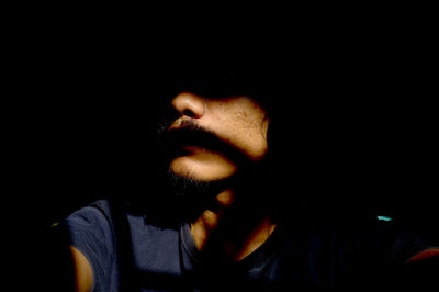 Close-up of man against black background