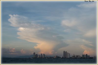 River in city against cloudy sky