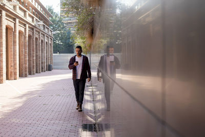 Man using smart phone while walking outdoors