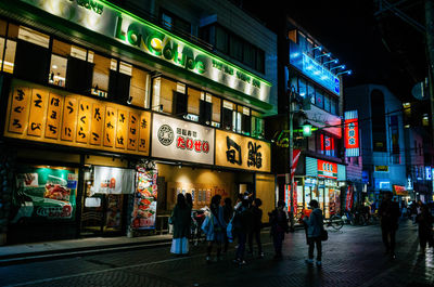 People at illuminated city at night