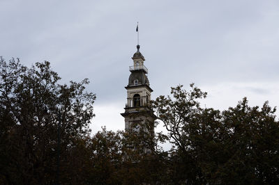 High section of dunedin town hall by trees against sky