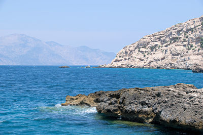 Scenic view of sea and mountains against clear sky