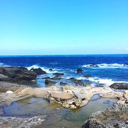 View of calm beach against blue sky