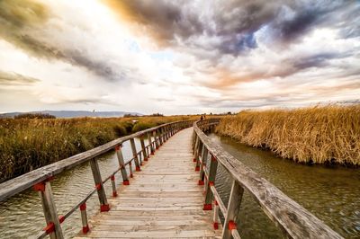 Boardwalk on beach against sky