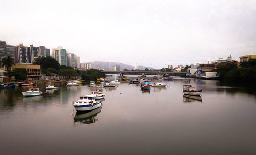 Boats in river with buildings in background