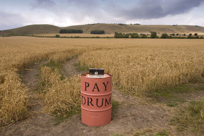 Information sign on field against sky