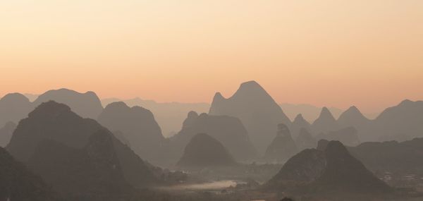 Scenic view of silhouette mountains against sky during sunset