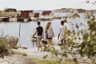 Rear view of friends looking at sea during summer vacation