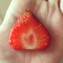 Close-up of hand holding strawberry