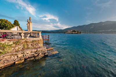 View of a building on lake orta with the island of san giulio in the background