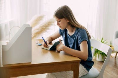 Young woman using digital tablet while sitting at home