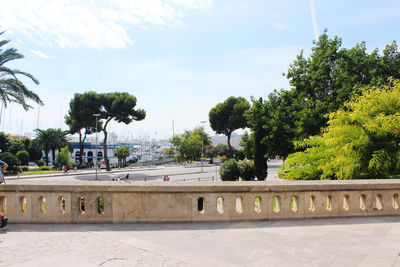 Built structure by trees against sky in city
