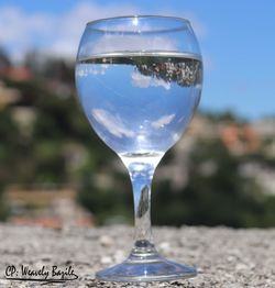 Close-up of wine glass on table against sky