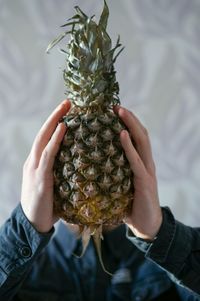 Close-up of hand holding pineapple