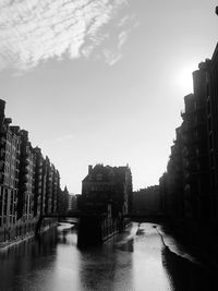 Canal amidst buildings in city against sky