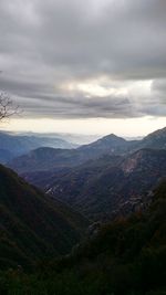 Scenic view of mountains against cloudy sky