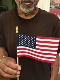 Midsection of man holding flag