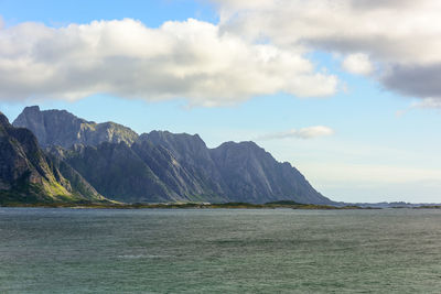 Scenic view of sea by mountains against sky